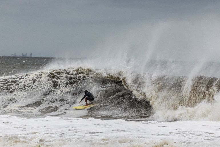 A surfer catches a wave as a nor'easter batters the US northeast coast, in Rockaway, New Jersey, US, September 26, 2026. REUTERS/Caitlin Ochs