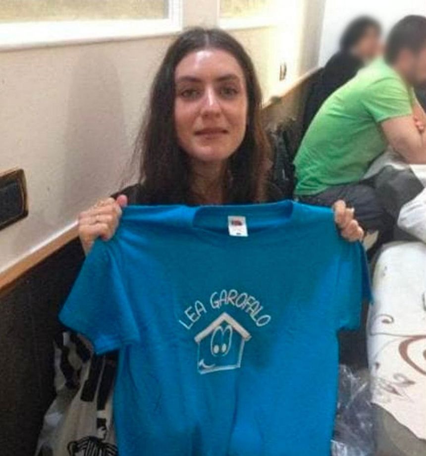 Denise Cosco holds up a T-shirt bearing her late mother’s name, in a family photo posted online after her death.