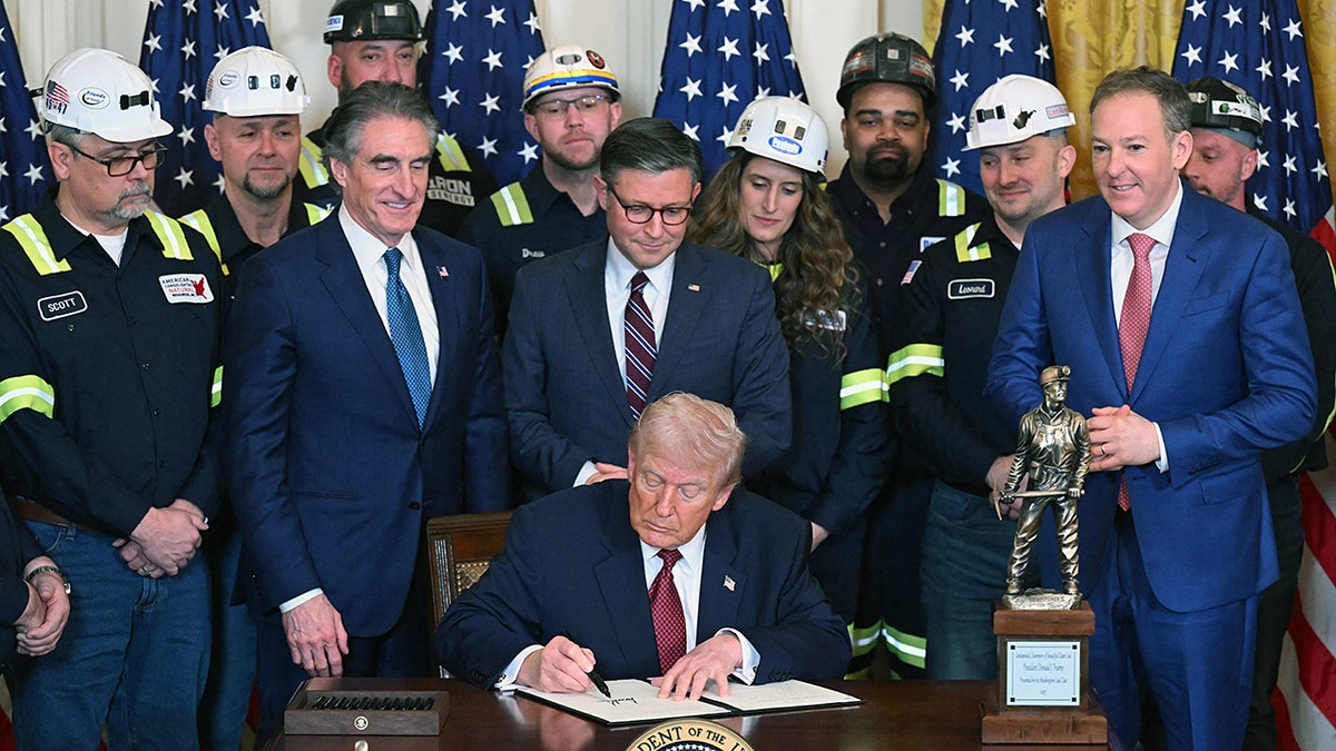 President Trump signs military/coal executive order while lawmakers and coal workers look on