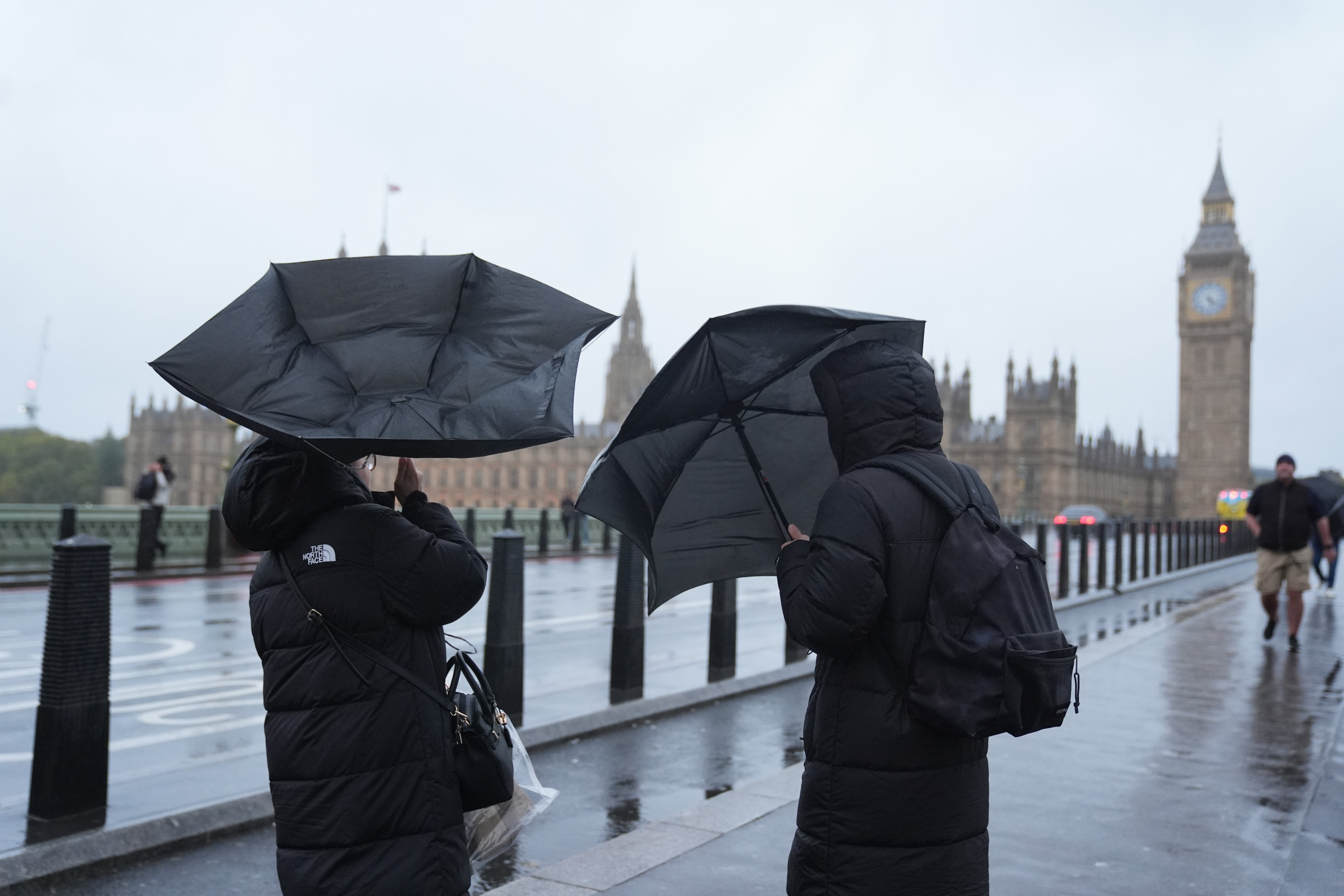People in the rain on Westminster Bridge, London. An amber weather warning is in place across Scotland, the north of England down to Carlisle and the north-east of Northern Ireland on Saturday