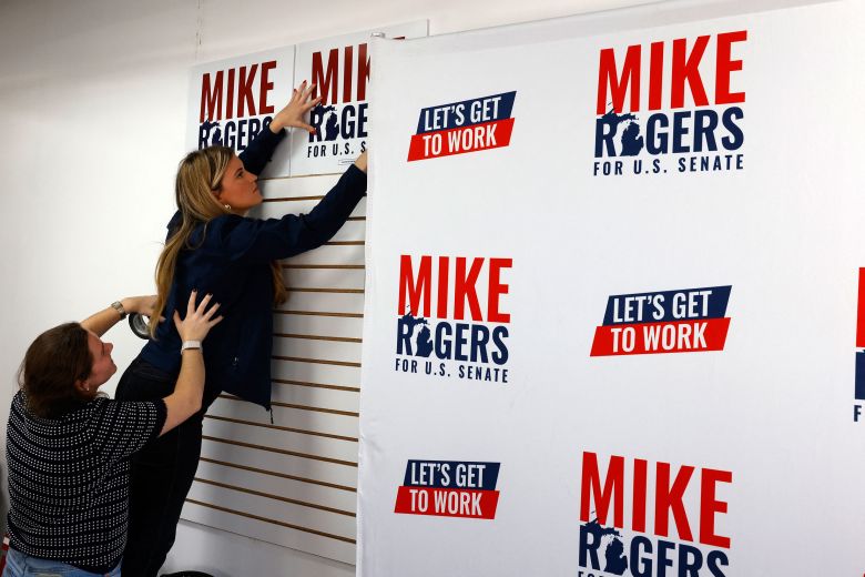Campaign workers hang signs at the new Rogers campaign office in Detroit on Saturday.