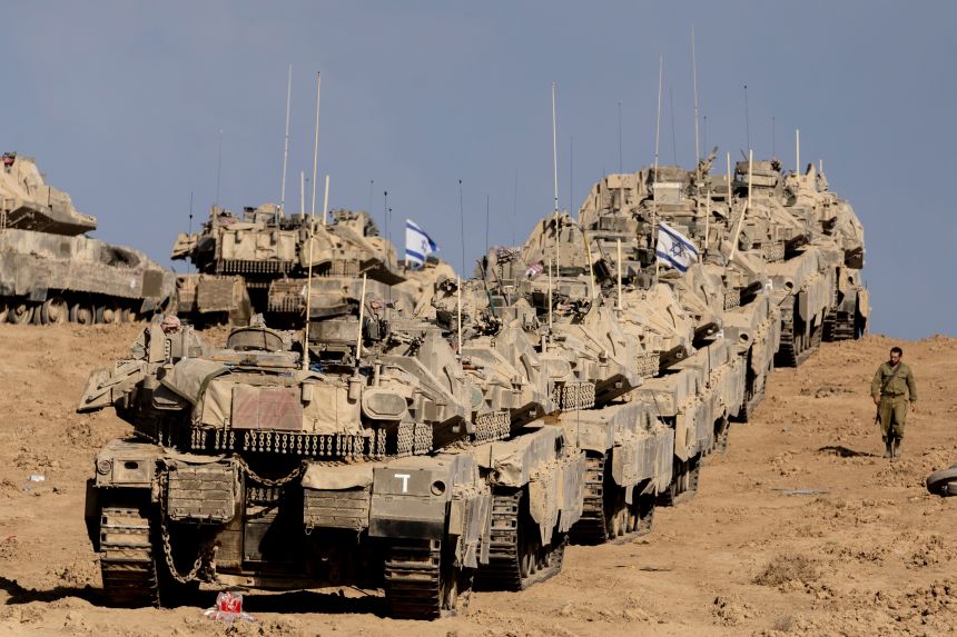 An Israeli soldier walks near tanks near the border with the Gaza Strip on September 17, 2025.