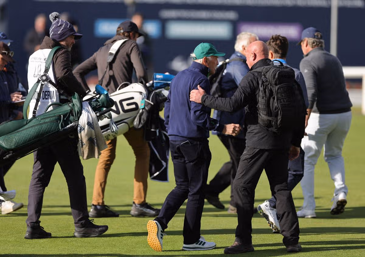 Dermot Desmond being escorted off by security from the 18th green