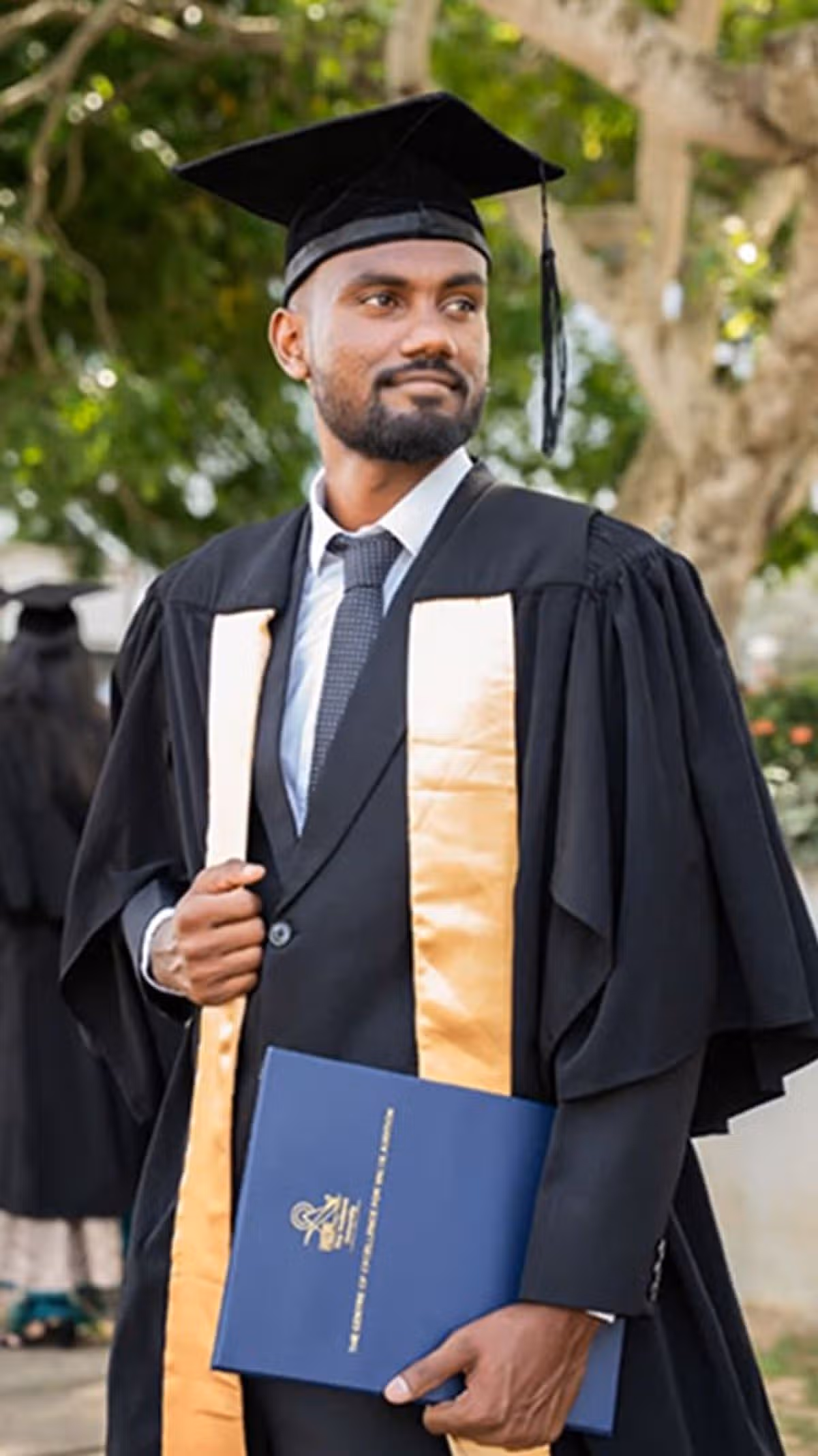 A man in graduation regalia.