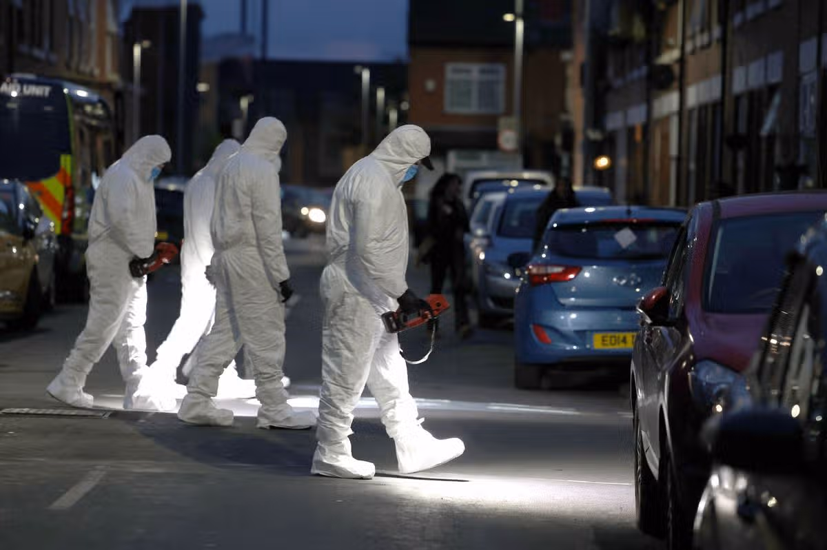 Police and forensic officers at the scene on Crondall street in Moss Side