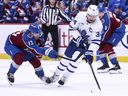 T.J. Hughes of the Colorado Avalanche and Auston Matthews of the Toronto Maple Leafs compete for the puck.