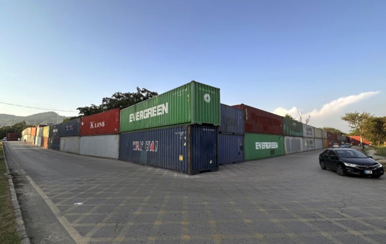 epa13248316 Commuters pass shipping containers lining Islamabads Red Zone, in Islamabad, Pakistan, 18 September 2026. Authorities have deployed containers and additional security personnel at key roads and entry points ahead of planned opposition protests and a Pakistan Tehreek-e-Insaf (PTI) long march scheduled for September 27, with the party demanding the release of former Prime Minister Khan. The security measures have disrupted traffic and raised concerns about restricted road access and the detention of commercial containers. EPA/SOHAIL SHAHZAD