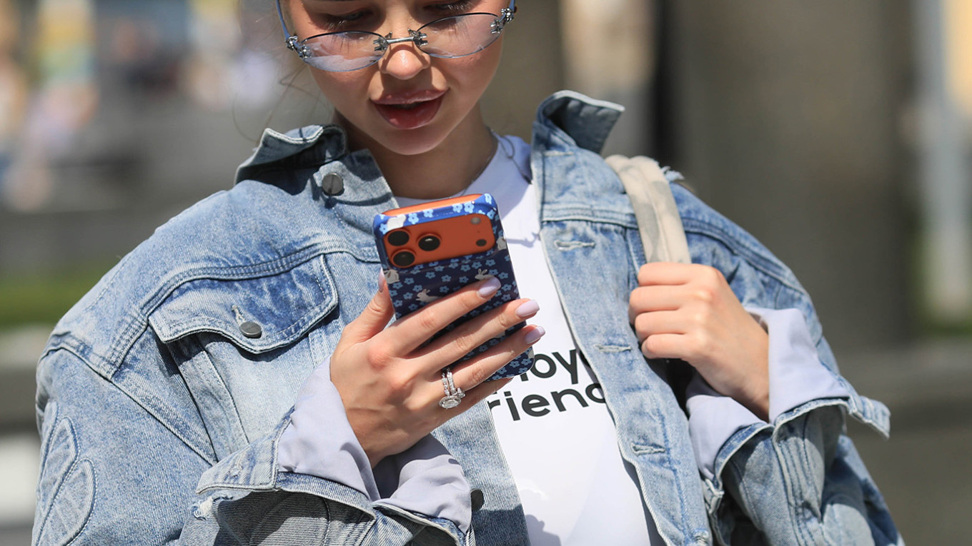A young woman looks at her phone in Moscow. Vasily Kuzmichenok / Moskva News Agency