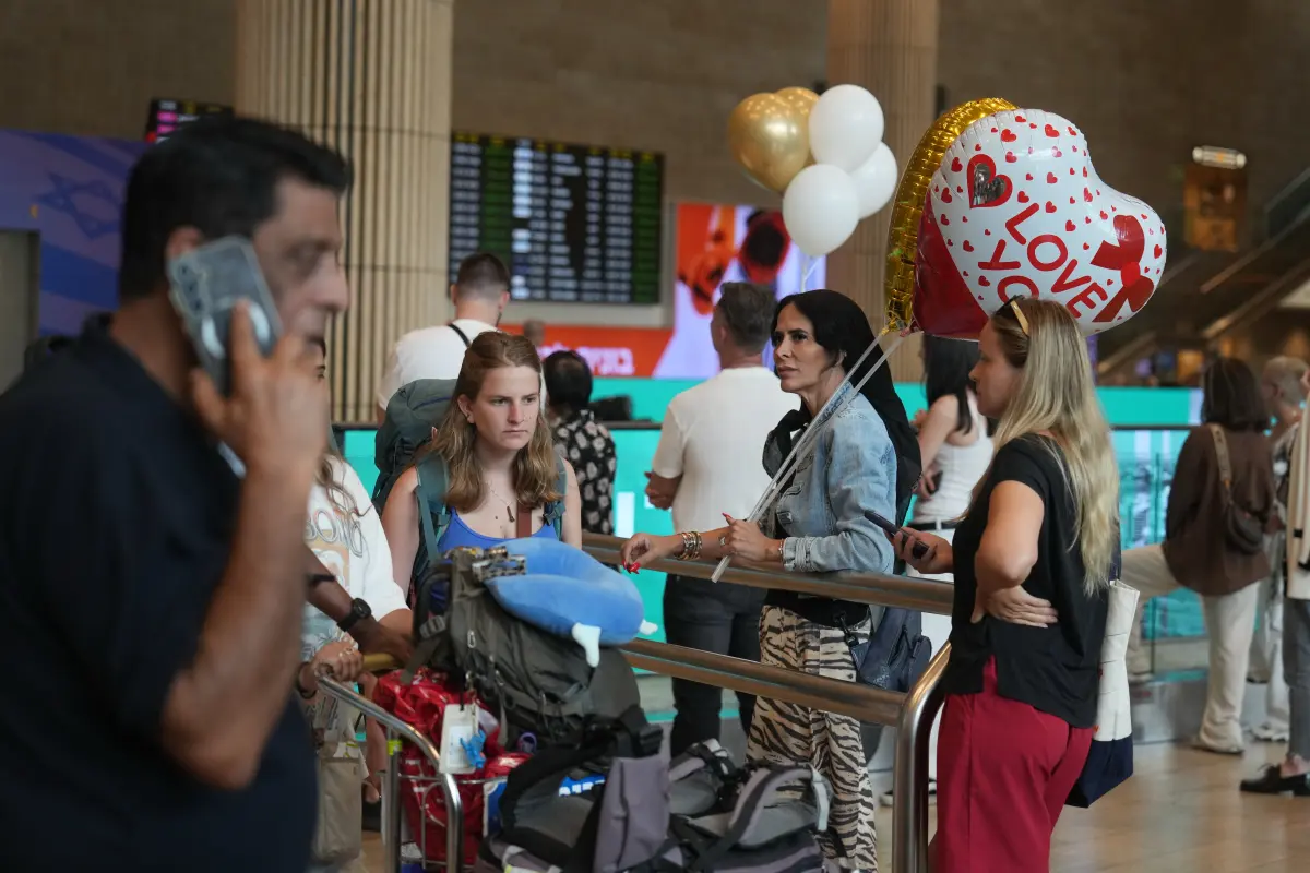 Holding balloons people wait for the arrival of passengers at Ben Gurion International Airport, near Tel Aviv, Israel, Wednesday.