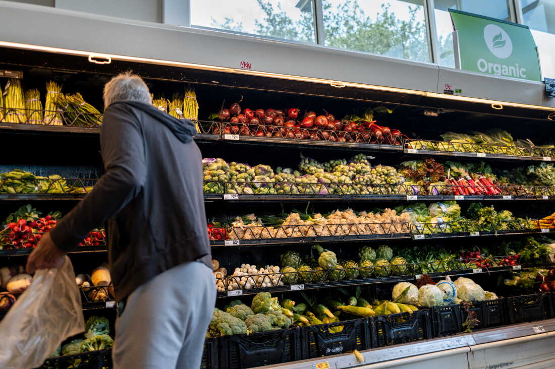 A man gathers produce from shelves of vegetables in an H-E-B grocery store in Austin, Texas, on May 11.