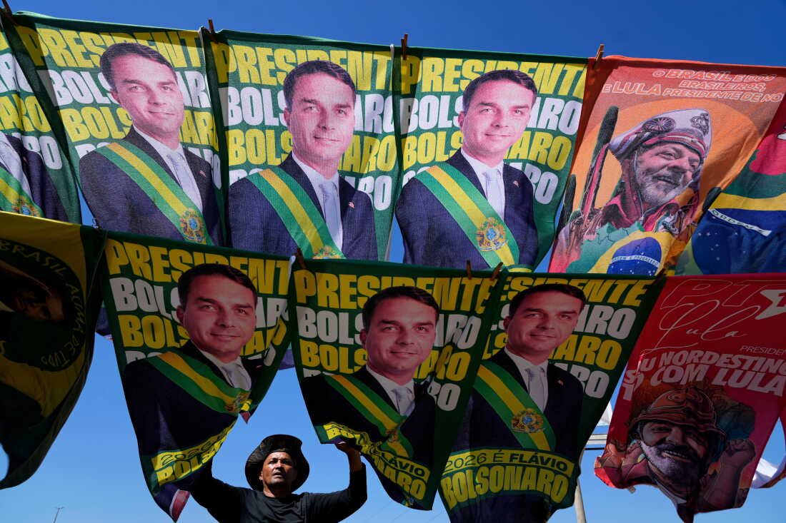 A street vendor sells campaign flags of presidential candidates Sen. Flavio Bolsonaro and current President Luiz Inacio Lula da Silva who is running for reelection in Brasilia, Brazil, Tuesday, Sept. 29, 2026.