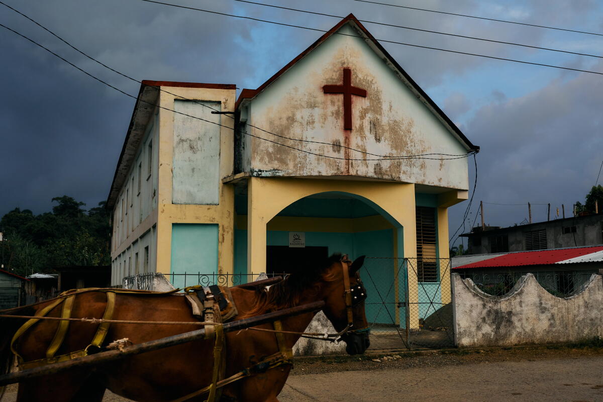 A horse pulling a carriage passes a church in Baracoa, on Cuba's eastern tip.