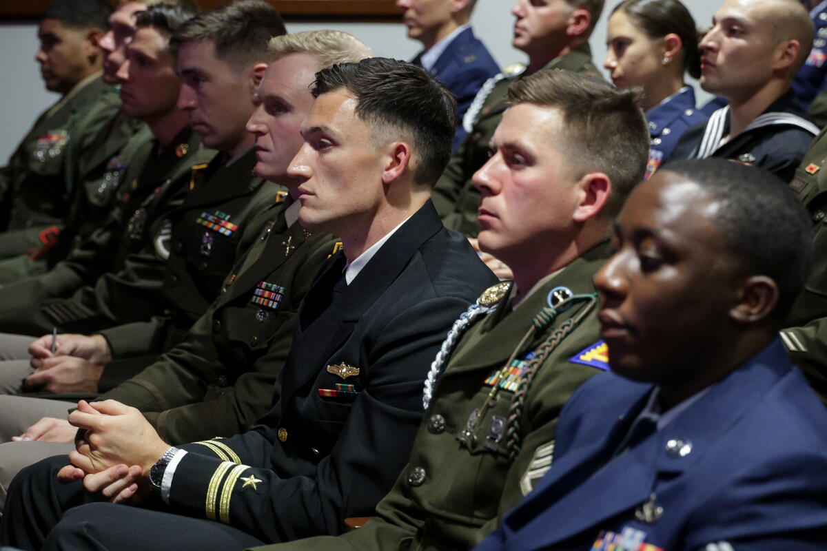 Members of the military listen to the Defense secretary.