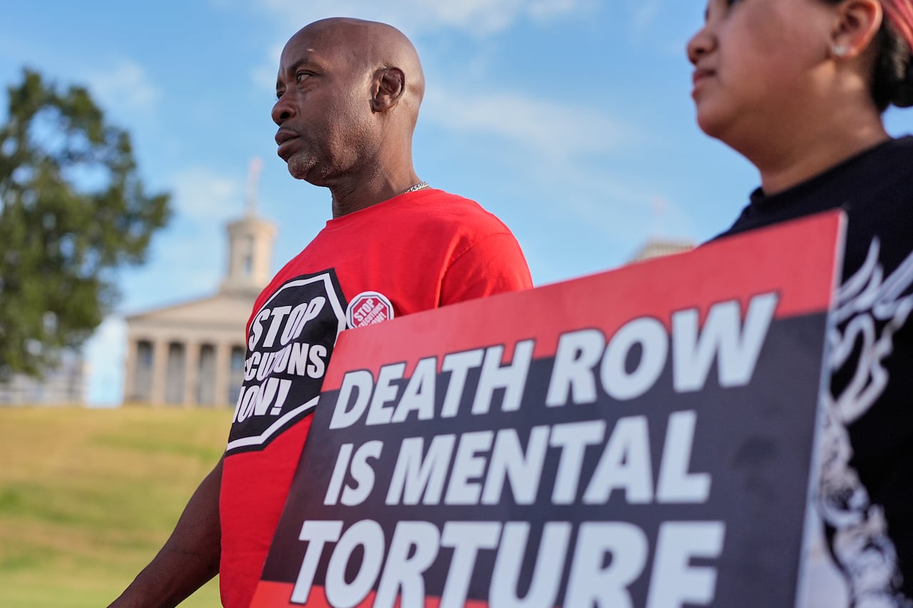 Protesters hold a sign that reads, 'Death Row is Mental Torture.'