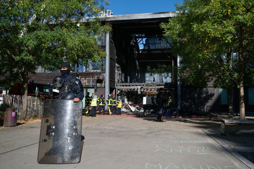 A security official looks on as firefighters survey the damaged entrance hall at the Nelson Mandela high school in Nantes, France, on Thursday.