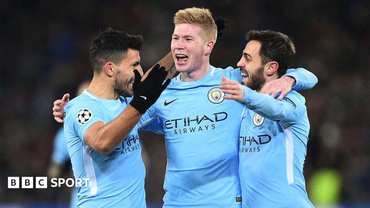 Sergio Aguero, Kevin de Bruyne, and Bernardo Silva celebrate by embracing one another after Manchester City scored a goal in the Champions League