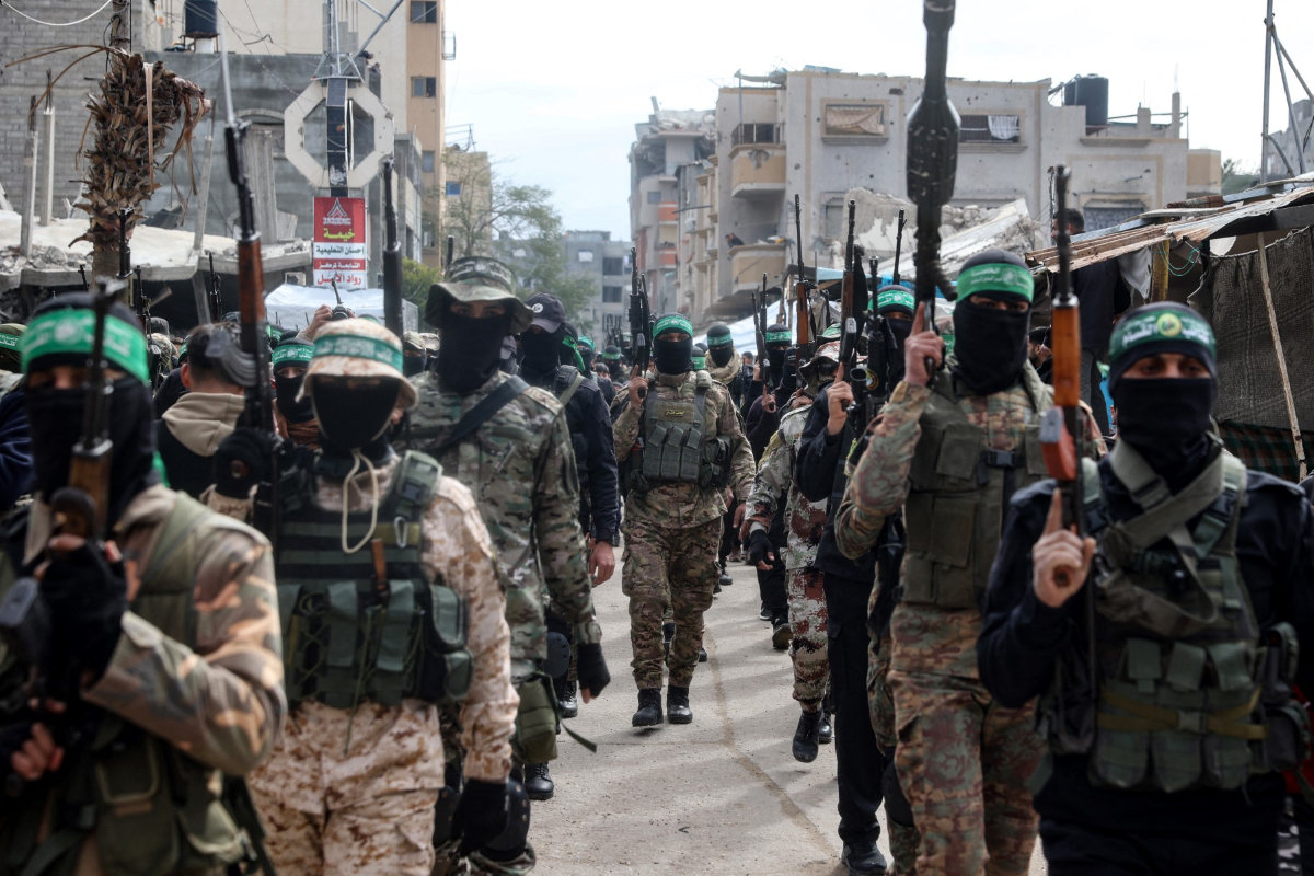 Palestinian fighters from the Ezzedine al-Qassam Brigades, the armed wing of Hamas, take part in the funeral ceremony of Marwan Issa, a top Hamas commander killed in March 2024, in the war-devastated Bureij refugee camp in the central Gaza Strip on February 7, 2025. (AFP)