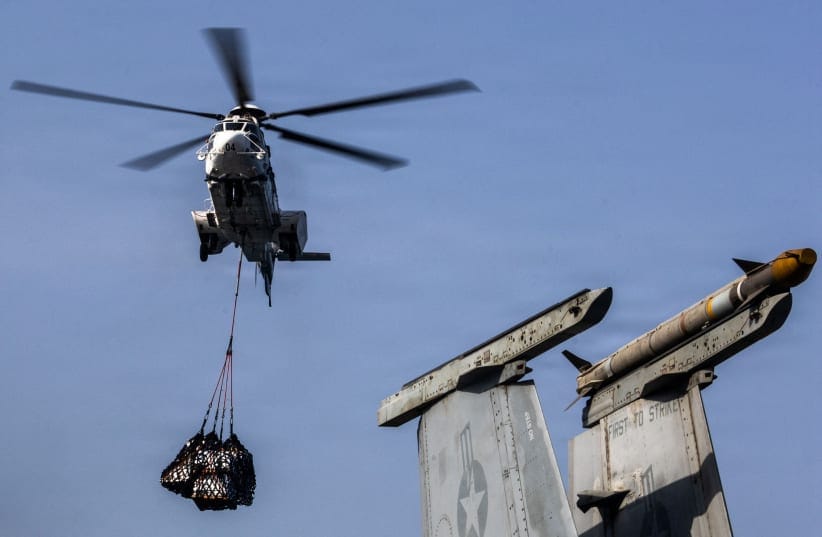 A Eurocopter AS-332 Super Puma helicopter delivers supplies on the flight deck of Nimitz-class aircraft carrier USS Abraham Lincoln, which is supporting US military operations in the war with Iran, during a replenishment-at-sea with fleet replenishment oiler USNS Henry J. Kaiser August 16, 2026. 
