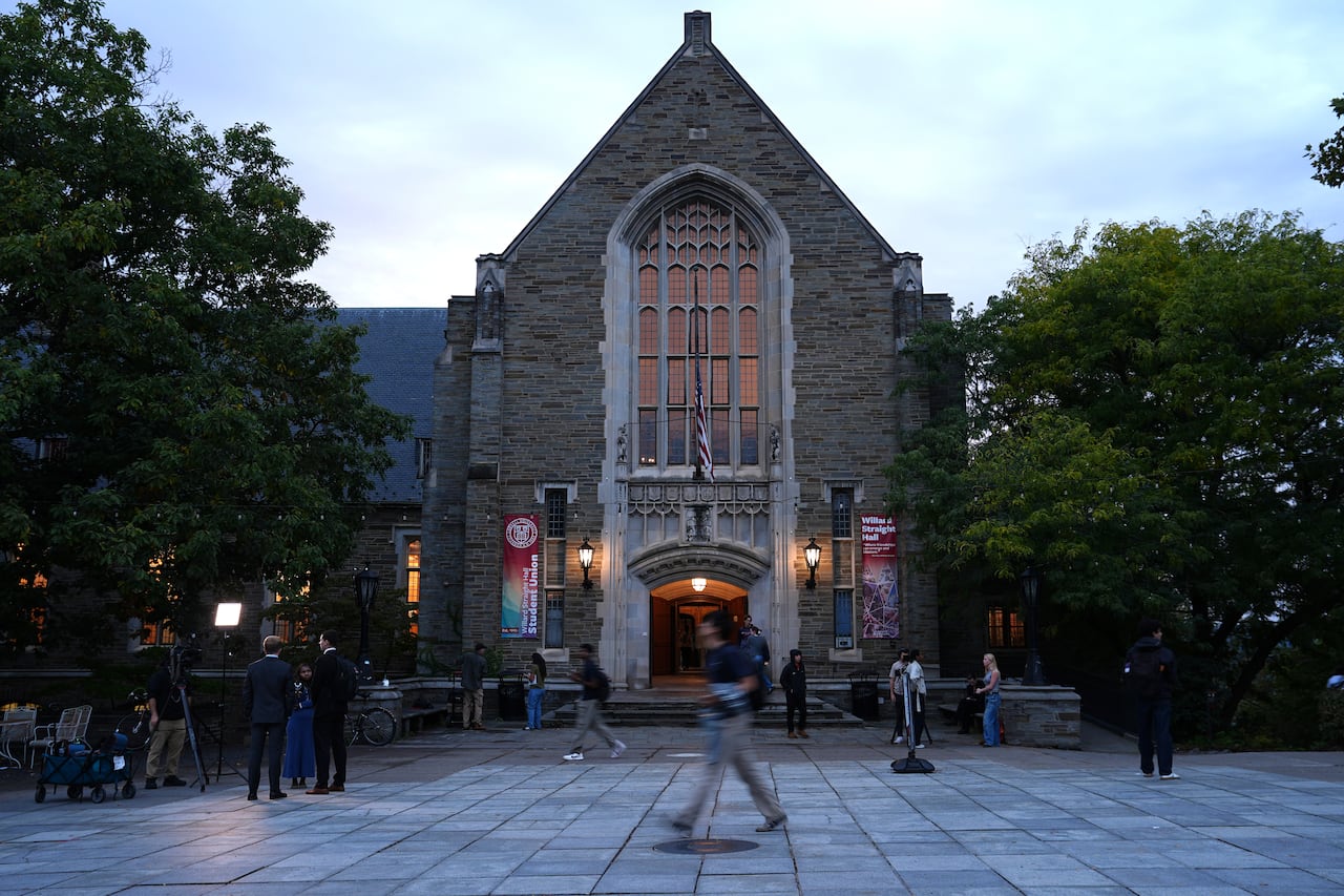 People walk in front of a campus building