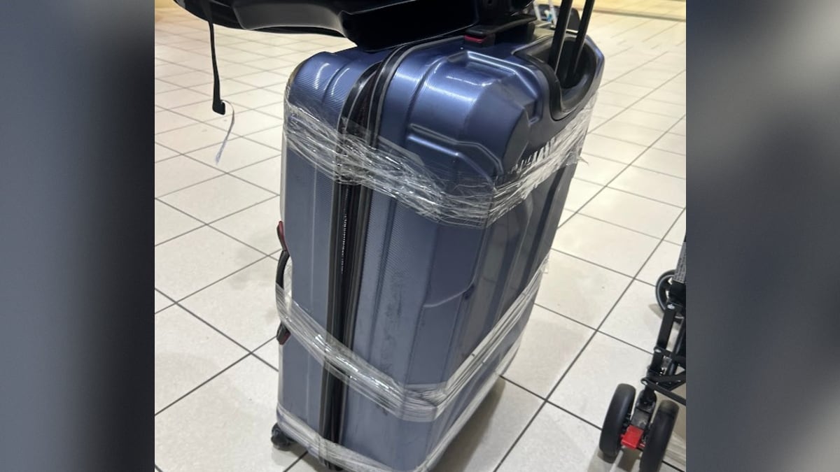 A hardshell suitcase with packing tape around it.