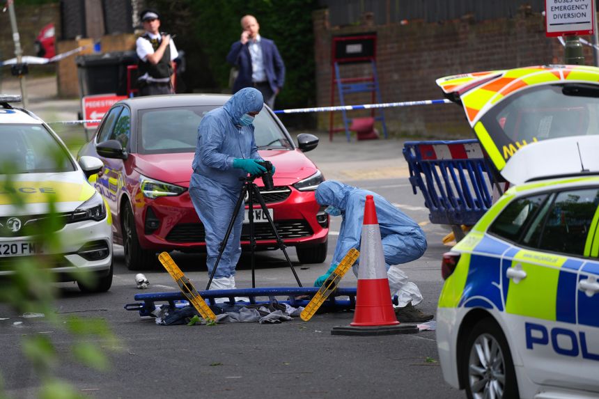 Forensic police officers photograph the scene where two people were stabbed in an antisemitic attack in April in London.
