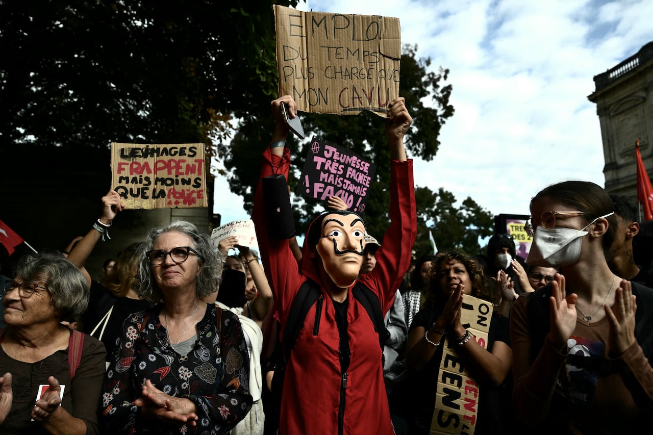 Several people are shown, some wearing masks, in an apparent outdoor demonstration.
