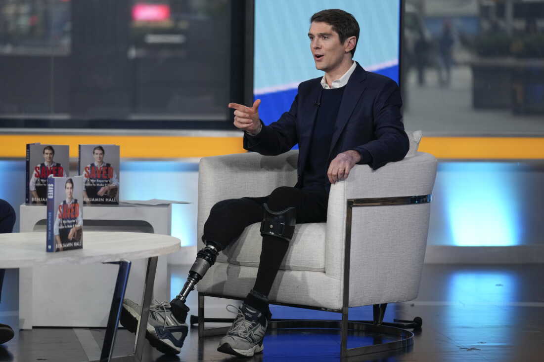 Benjamin Hall is interviewed about his book, "Saved: A War Reporter's Mission to Make It Home," on "Fox & Friends" on March 10, 2023. He has a metal prosthetic leg and a leg brace on his other leg.