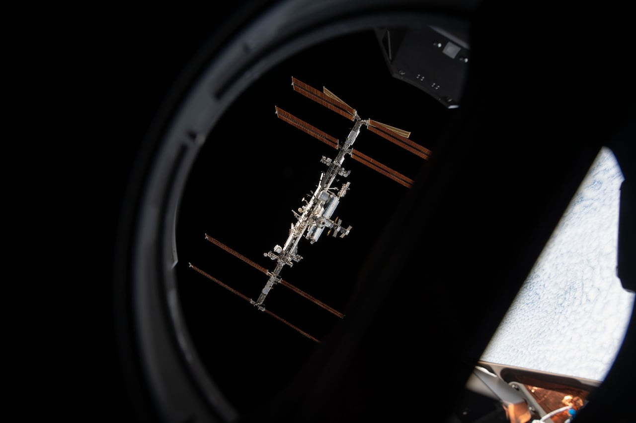 The International Space Station is seen through the window of a spacecraft.