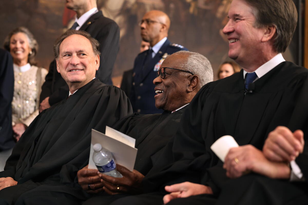 Supreme Court Associate Justices Samuel Alito, Clarence Thomas and Brett Kavanaugh share a laugh