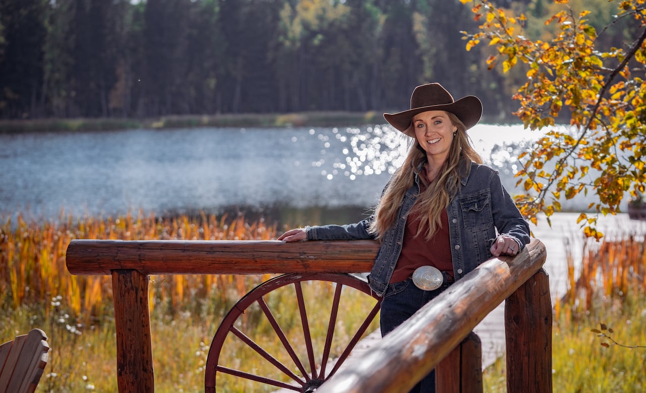 Woman in cowboy hat smiles.