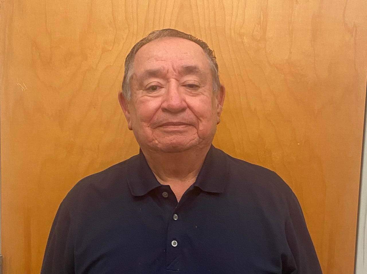 Headshot of a man wearing a black top.