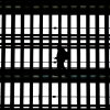 In this file photo, a man using a smartphone passes through the arched windows at Grand Central Terminal in New York City on March 24, 2025.