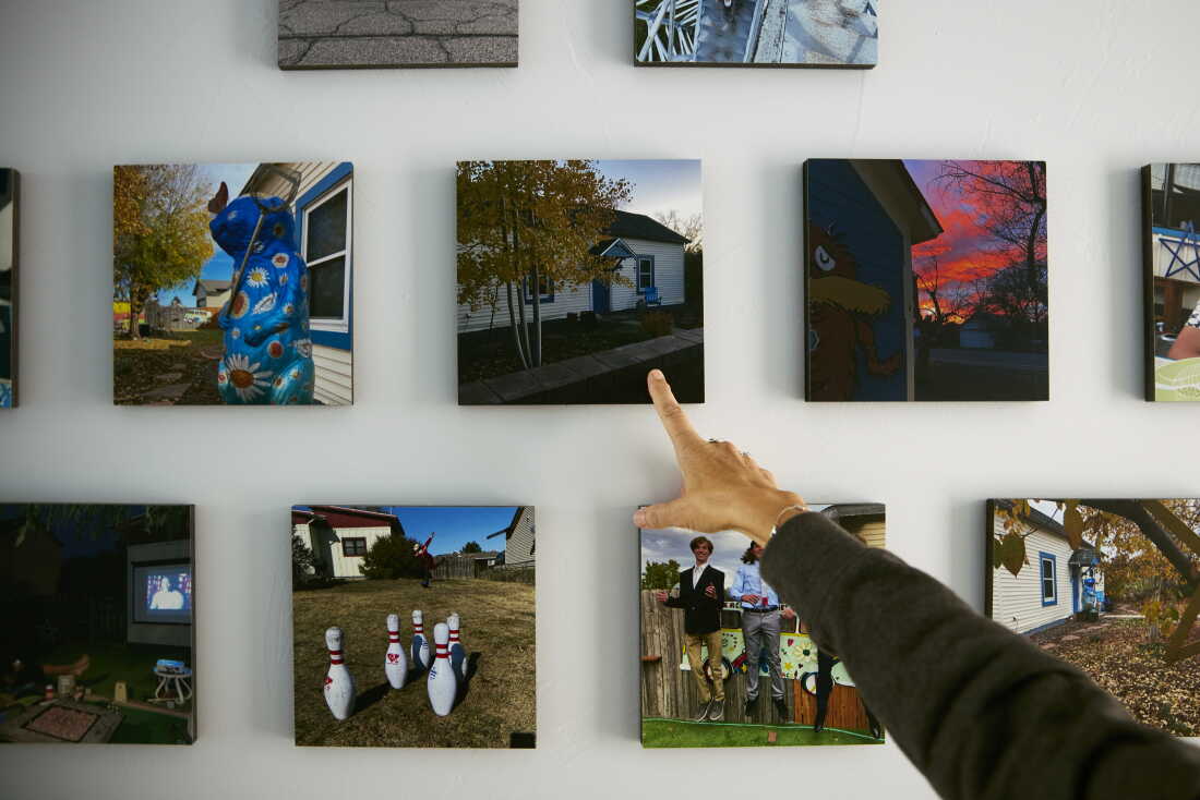 Daryl McCool points to photographs displayed in her rebuilt home in Superior, Colorado. McCool lost the small, single-story historic miner’s shack where she and her family had lived for 25 years when it was destroyed in the Marshall Fire on Dec. 30, 2021. The fire is part of the broader climate-related costs facing Colorado communities.