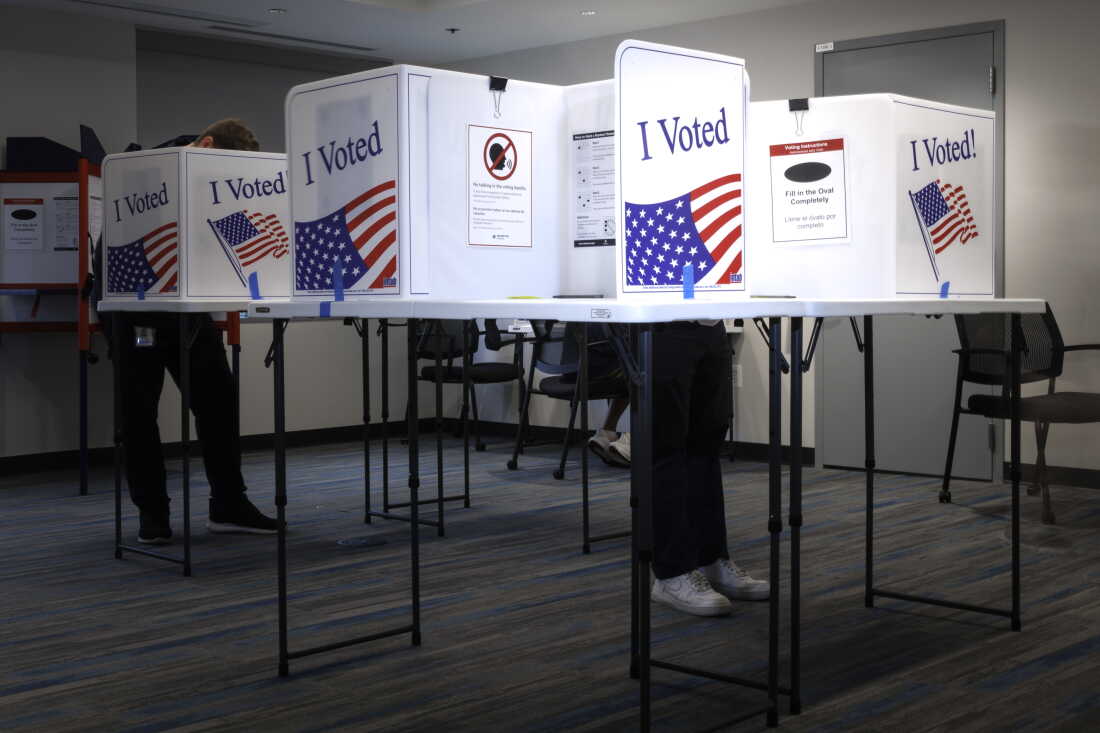 Voters standing at tables with privacy partitions cast their ballots inside the Arlington County Courthouse in Arlington, Virginia, on September 18.