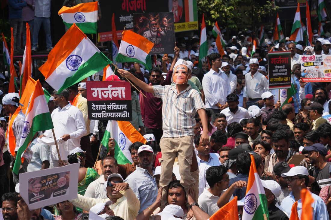 A protester wears a mask depicting Chief Election Commissioner Gyanesh Kumar with the words "vote theft" during a protest organized by Shiv Sena (UBT) and the Maharashtra Navnirman Sena , demanding his resignation and the suspension of the Special Intensive Revision (SIR) of electoral rolls, in Mumbai, India, Sunday, Oct. 4, 2026.(AP Photo/Rafiq Maqbool)