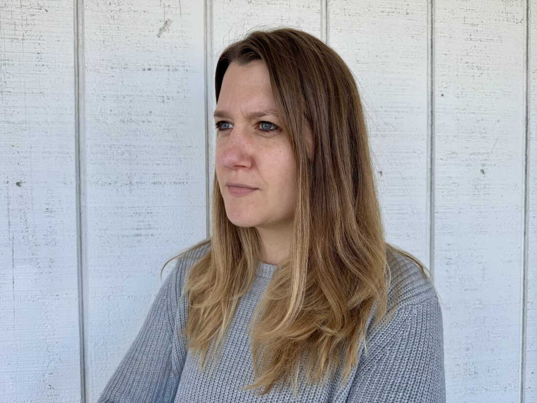Carrie Goldstein stands outside her home on October 4, 2026. Home prices and mortgage rates prevent her from moving.