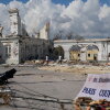 People walk past damage from Hurricane Melissa in Black River, Jamaica on Thursday, Oct. 30, 2025.