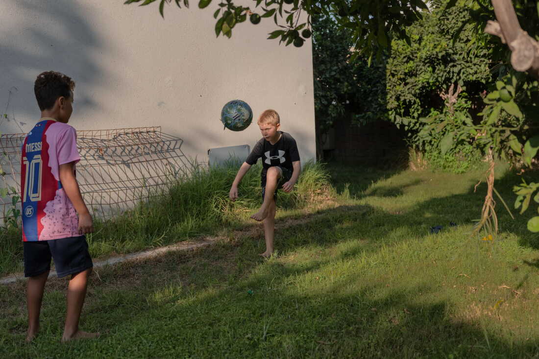 ZIKIM, ISRAEL, AUGUST 31, 2026: (Middle) Yoav, the son of Shahar Goldenberg - Kibbutz Zikim's management member, plays with his friend outside their home. Credit: Amit Elkayam for NPR.