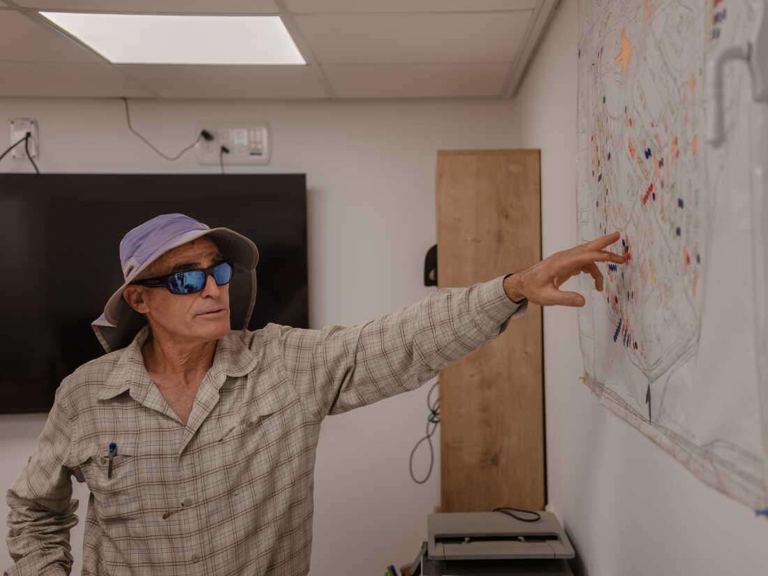 NIR OZ, ISRAEL, AUGUST 31, 2026: Ron Bahat, Nir Oz's reconstruction manager, showcases a map outlining reconstruction plans for the kibbutz. Credit: Amit Elkayam for NPR.