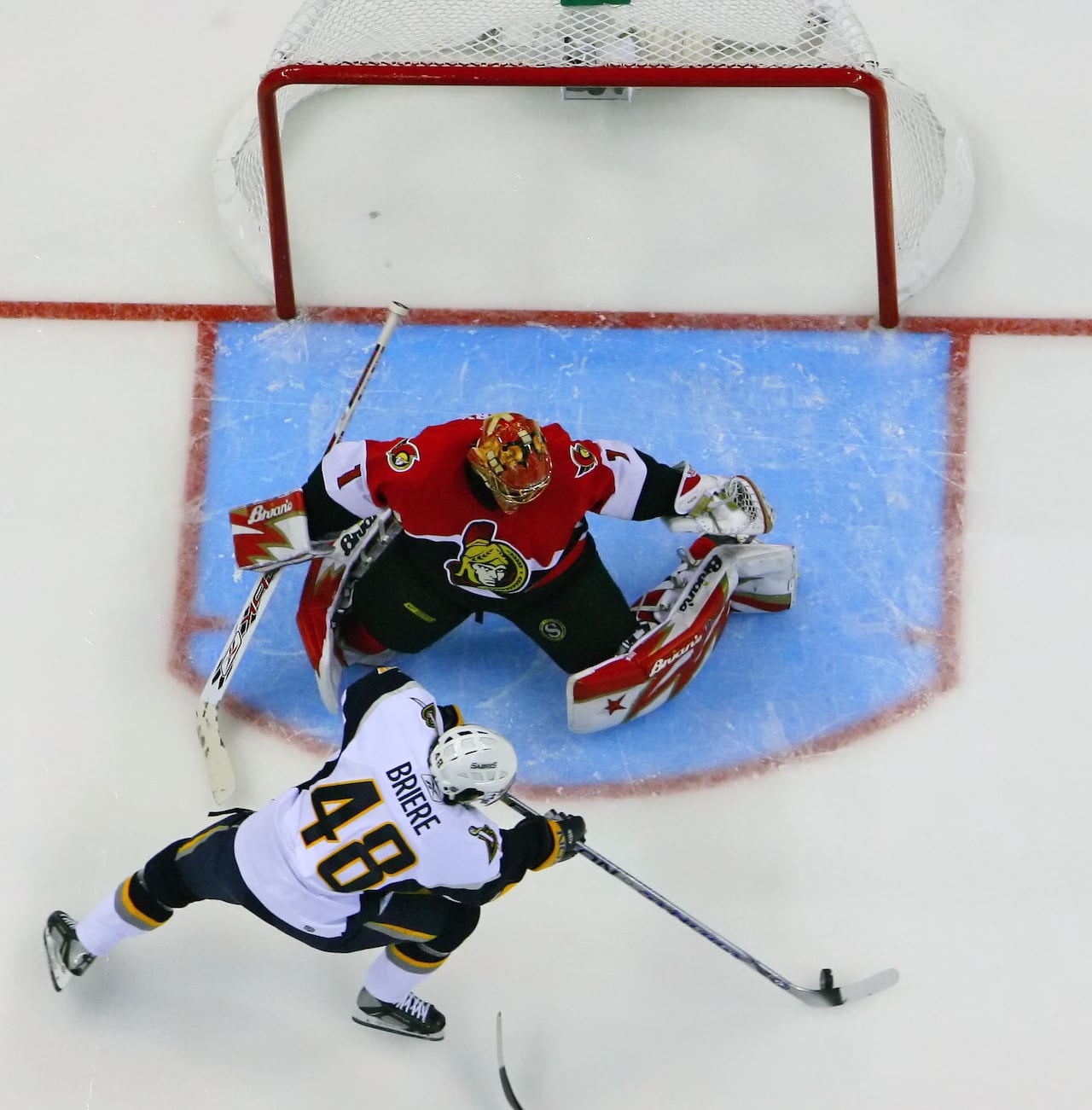 A hockey goalie makes a pad save during a playoff game.