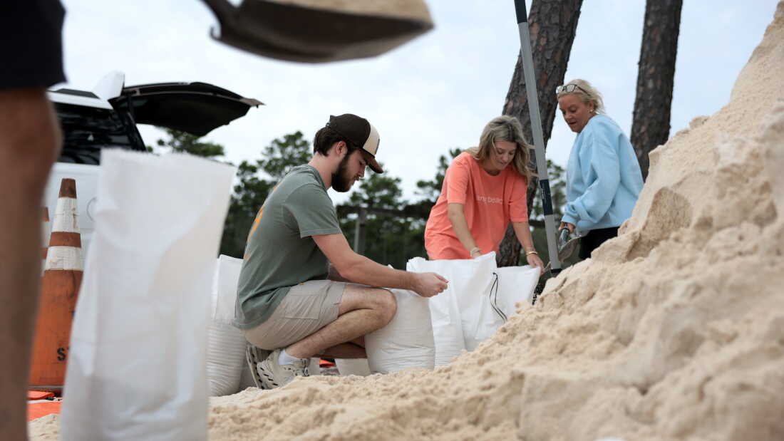 Brian Brunick (C) and other residents fill sandbags that were provided by the city of Orange Beach as they prepare for the possible arrival of Hurricane Isaias on Oct. 8, 2026, in Orange Beach, Alabama.