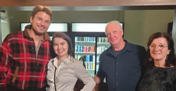 Four people in a theatre lobby.