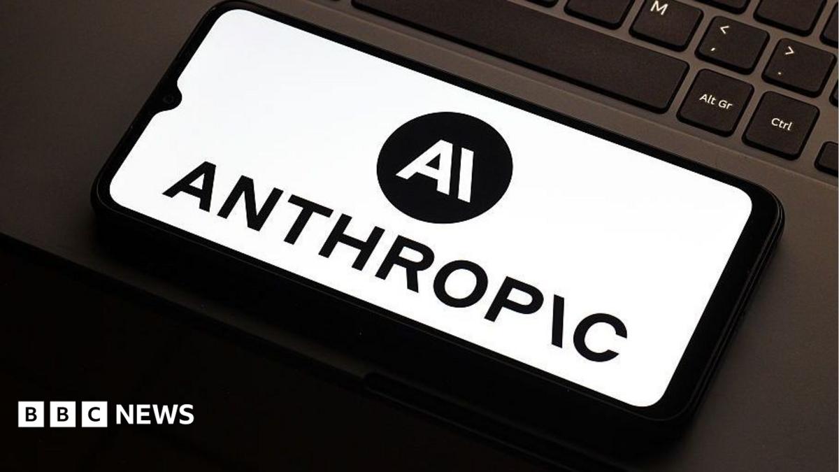 Anthropic logo on a smarthphone which is lying flat on the mousepad of a laptop. Only a partial keyboard of the laptop is visible.