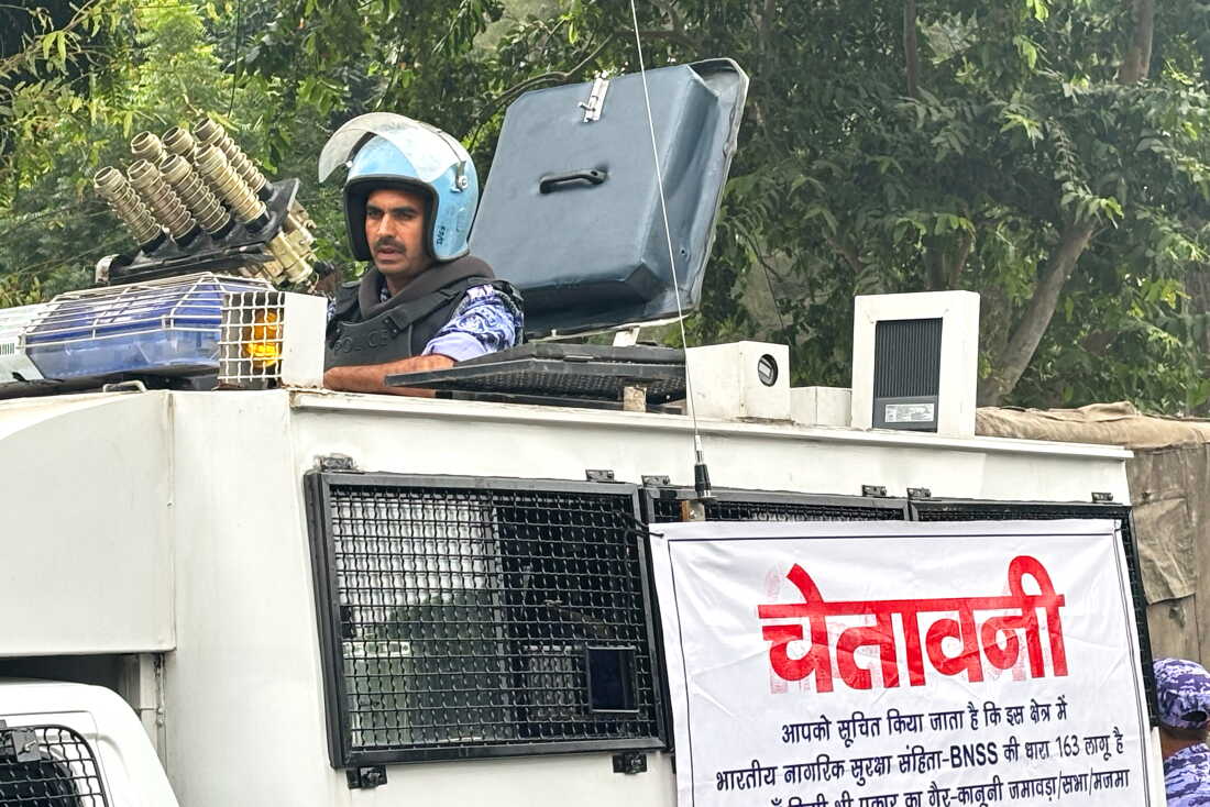 An armored vehicle with a banner warning citizens against unlawful gathering stands near the venue of a youth protest demanding the resignation of the country's election chief Gyanesh Kumar, in New Delhi, India, Saturday, Oct. 10, 2026. (AP Photo/Manish Swarup)