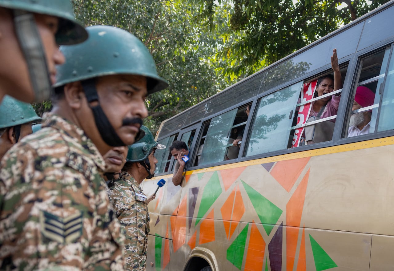 Protesters shout slogans from a police bus after being detained