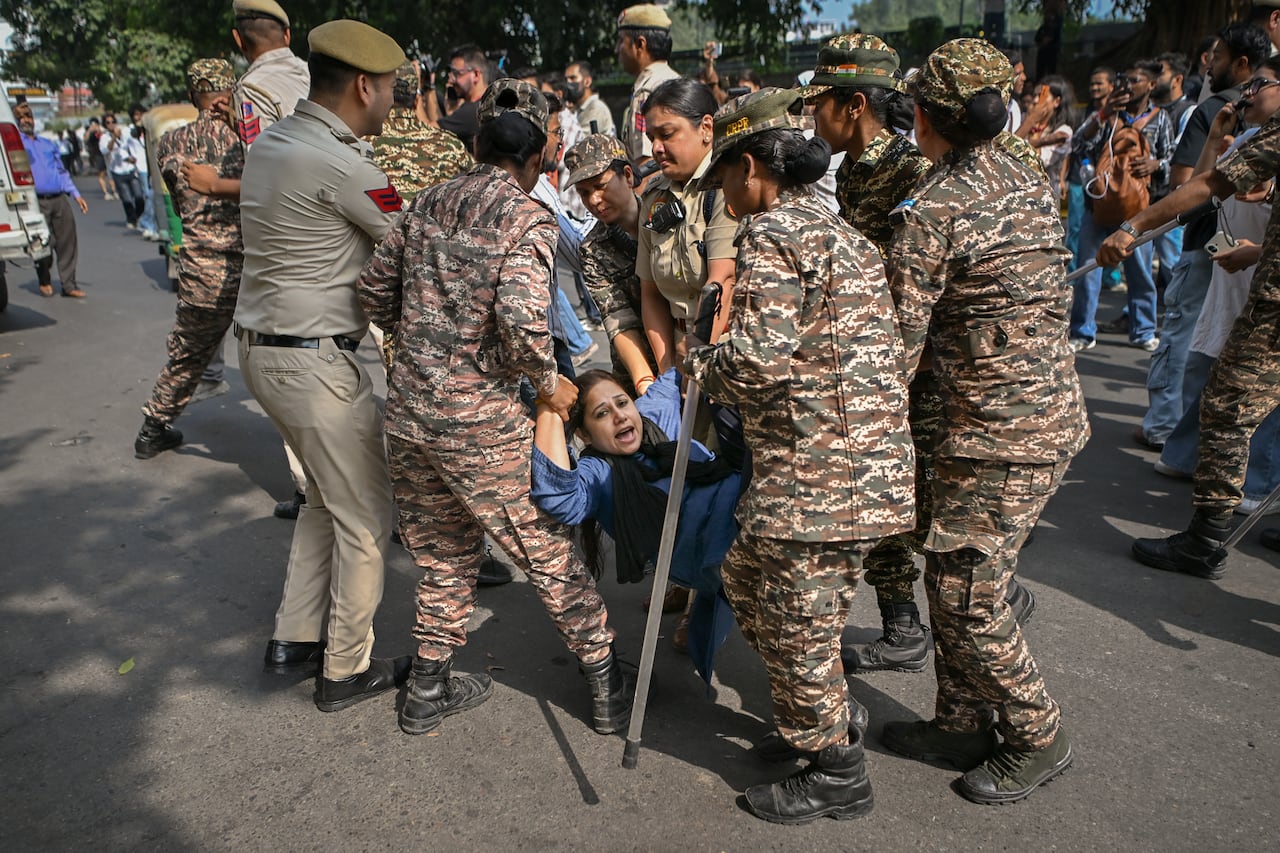 Police officers detain a protester during a demonstration