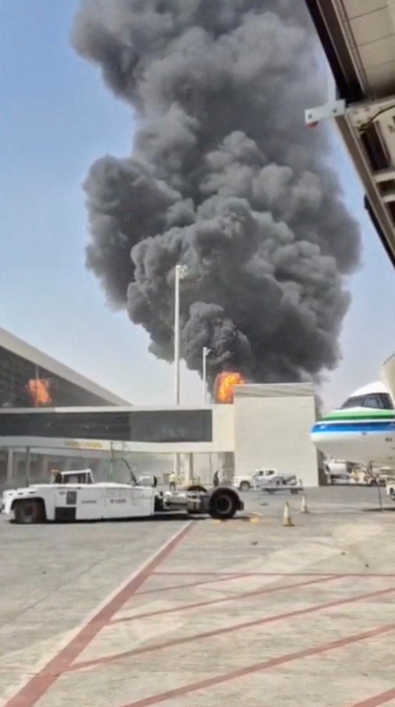 Smoke and fire rise from an airport in this screenshot of a video.