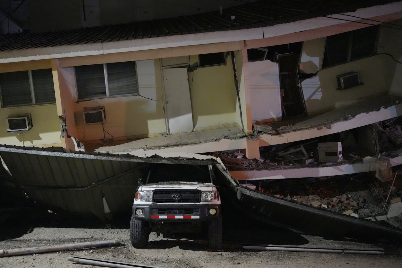 A car crushed under a building.