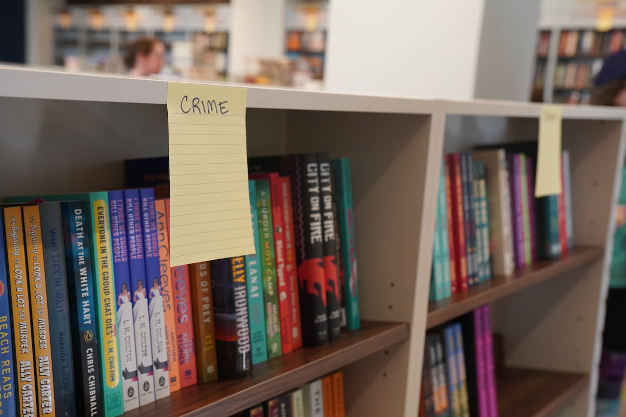 A photo of a bookshelf full of new books and labelled "Crime."