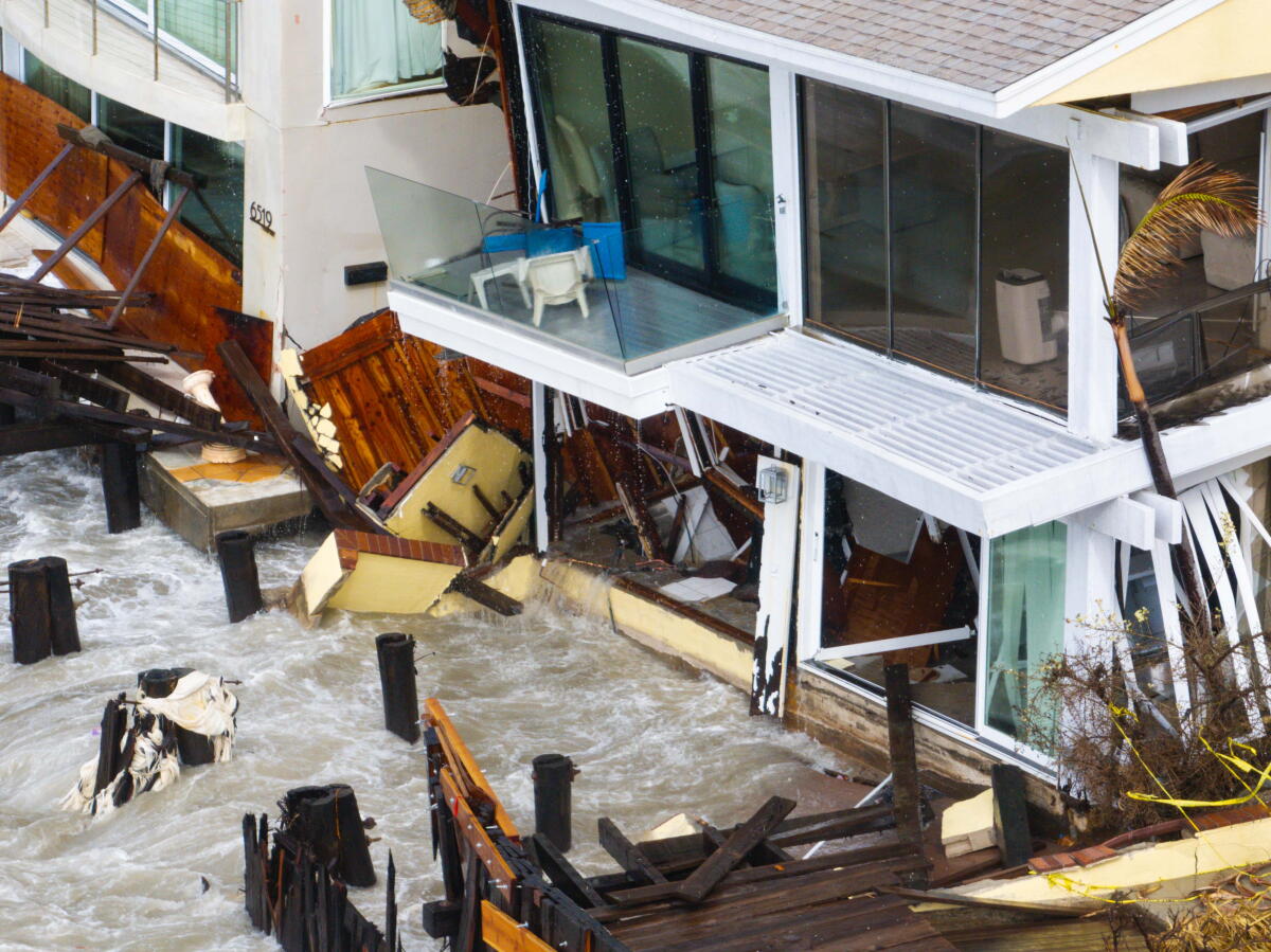 A drone photograph of waves crashing against East Seaside Walk as homes collapse on the Long Beach Peninsula.